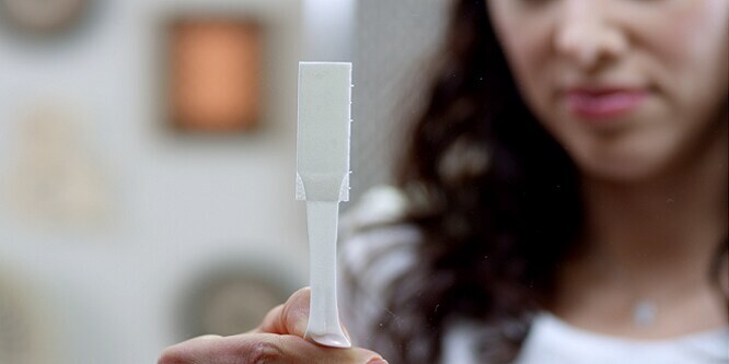 Woman showing how to remove Command™ Picture hanging Strips
